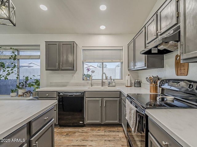 kitchen featuring a sink, black appliances, under cabinet range hood, light countertops, and recessed lighting