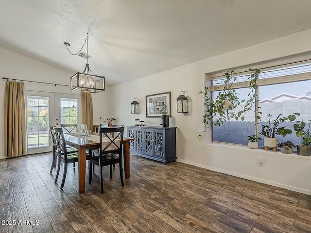 dining area with french doors, dark wood-type flooring, vaulted ceiling, a notable chandelier, and baseboards
