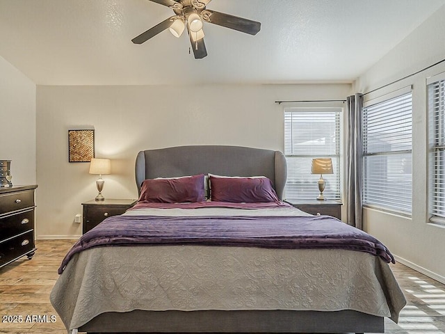 bedroom featuring ceiling fan, baseboards, and light wood-type flooring