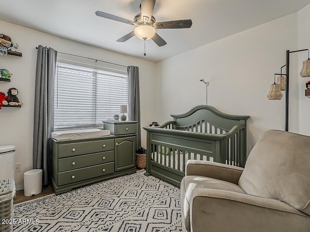 bedroom featuring a ceiling fan and a crib