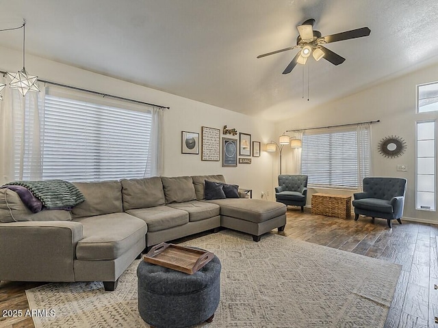 living room with ceiling fan, wood-type flooring, and vaulted ceiling