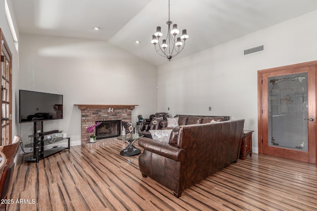 15825 N 45th St, Phoenix, AZ 85032 - living room with wood finished floors, a chandelier, high vaulted ceiling, a brick fireplace, and baseboards