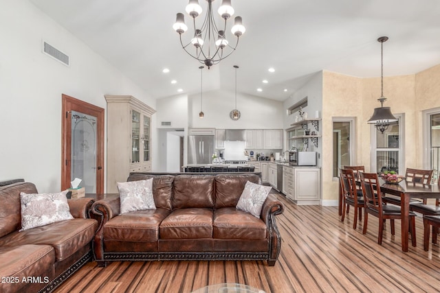 15825 N 45th St, Phoenix, AZ 85032 - living room with light wood-style flooring, a chandelier, high vaulted ceiling, and recessed lighting