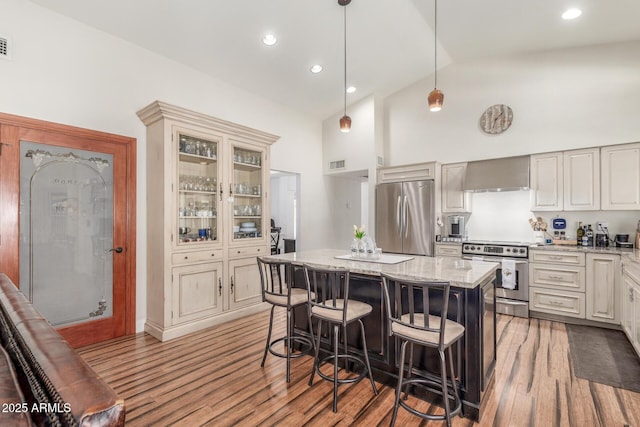 15825 N 45th St, Phoenix, AZ 85032 - kitchen with wall chimney exhaust hood, stainless steel appliances, high vaulted ceiling, light stone countertops, and a kitchen bar