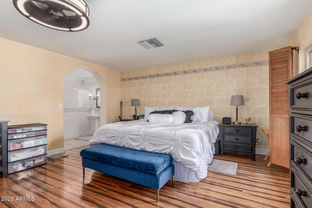 15825 N 45th St, Phoenix, AZ 85032 - bedroom with tile walls, wood finished floors, arched walkways, ensuite bath, and a sink