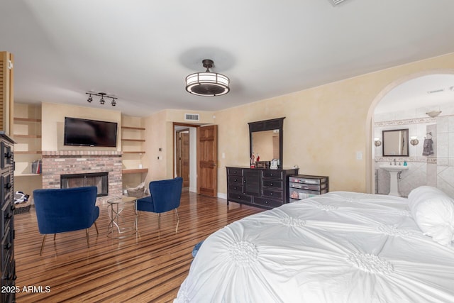 15825 N 45th St, Phoenix, AZ 85032 - bedroom featuring arched walkways, a brick fireplace, wood finished floors, and ensuite bathroom