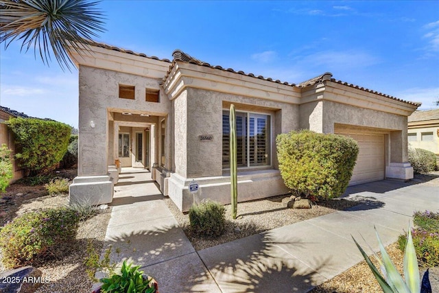 mediterranean / spanish home with concrete driveway, an attached garage, and stucco siding