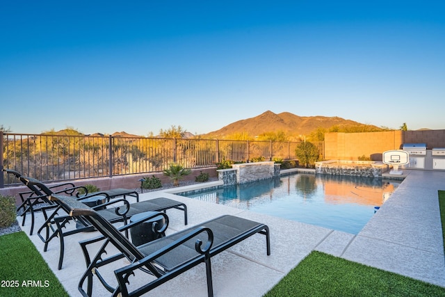 view of swimming pool with a patio area, a fenced backyard, a mountain view, and a fenced in pool