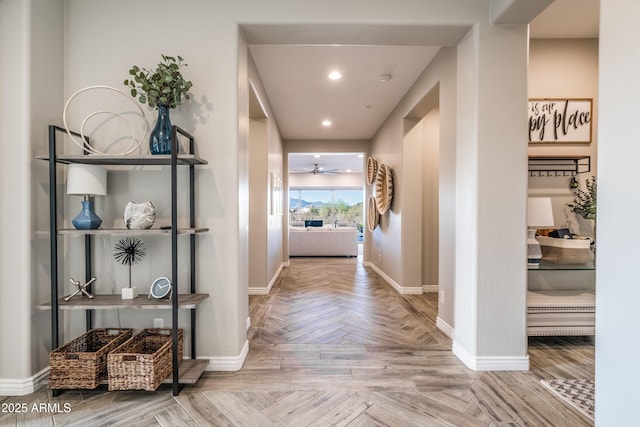 hall with recessed lighting and baseboards