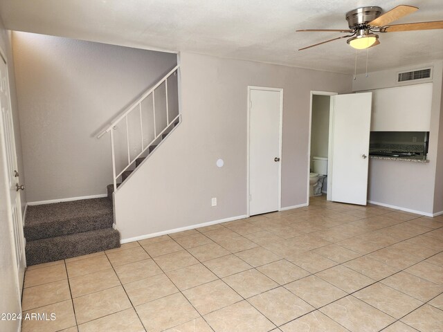 tiled spare room featuring ceiling fan