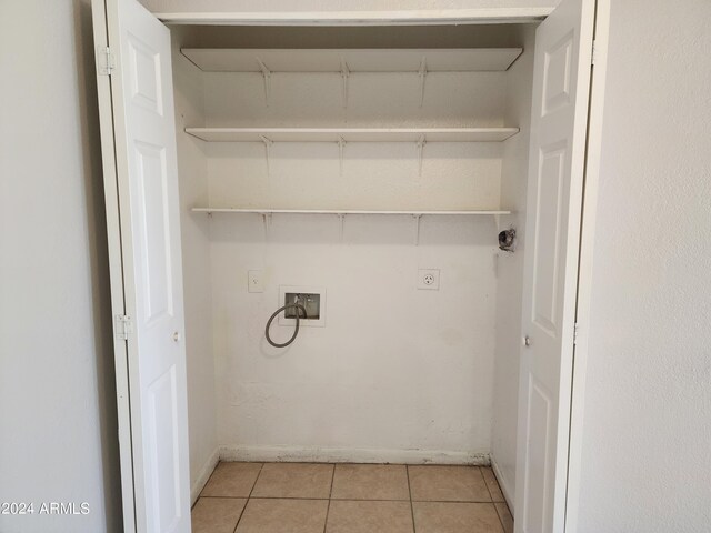 laundry area with hookup for a washing machine, hookup for an electric dryer, and light tile patterned floors