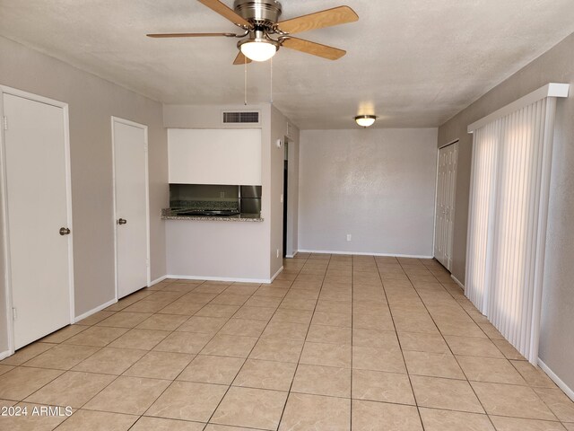 tiled empty room with ceiling fan