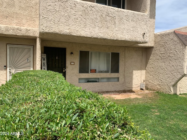 doorway to property with a yard