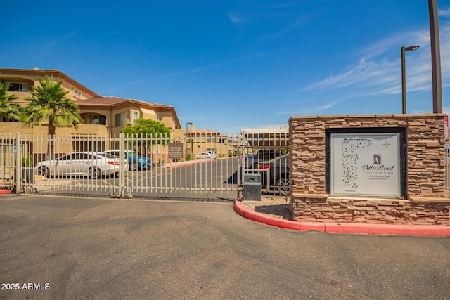2134 E Broadway Rd Unit 2030, Tempe, AZ 85282 - view of asphalt street with curbs, a gate, a gated entry, and street lights