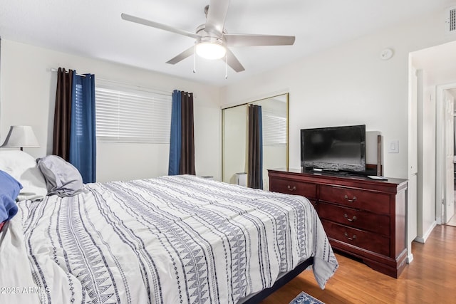 bedroom featuring ceiling fan, wood-type flooring, and a closet