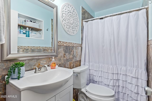 bathroom featuring tile walls, vanity, and toilet