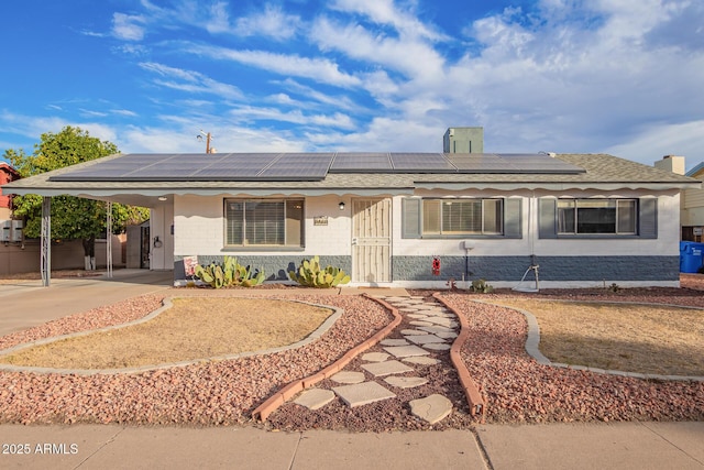 ranch-style home featuring solar panels