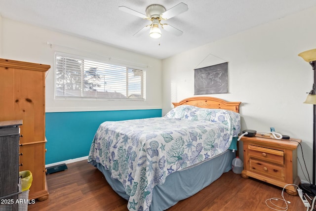 bedroom with ceiling fan, dark hardwood / wood-style floors, and a textured ceiling