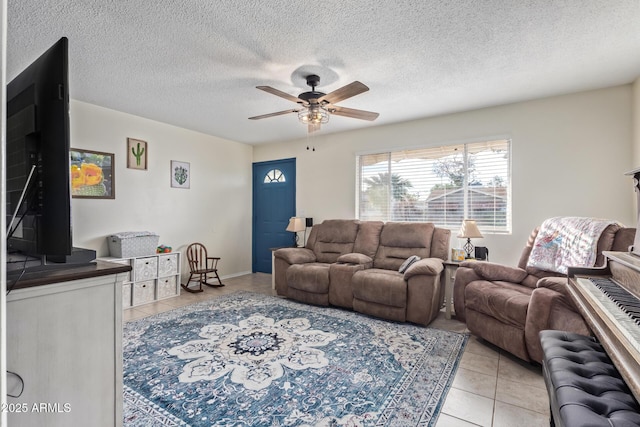 living room with light tile patterned flooring, ceiling fan, and a textured ceiling