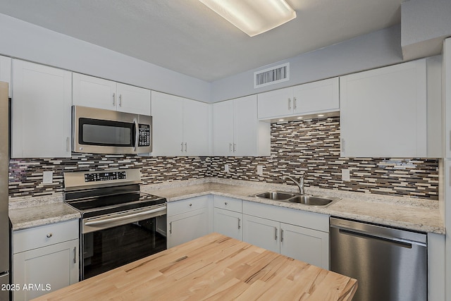 11210 S Bannock St, Phoenix, AZ 85044 - kitchen with white cabinets, a sink, stainless steel appliances, tasteful backsplash, and visible vents
