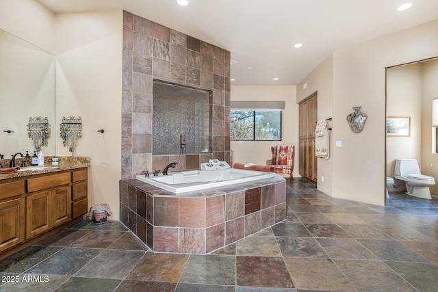 bathroom featuring a relaxing tiled tub, a bidet, vanity, and toilet