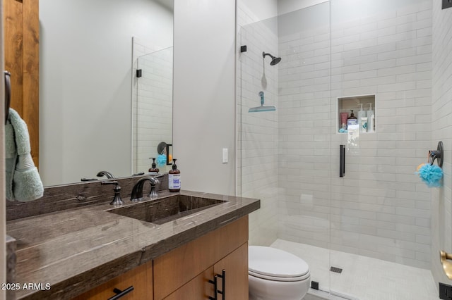 bathroom with a shower with door, vanity, and toilet