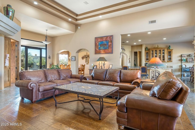 living room featuring a towering ceiling and hardwood / wood-style floors