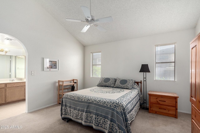 10235 N 31st St Unit 2, Phoenix, AZ 85028 - bedroom with light carpet, multiple windows, a textured ceiling, vaulted ceiling, and connected bathroom