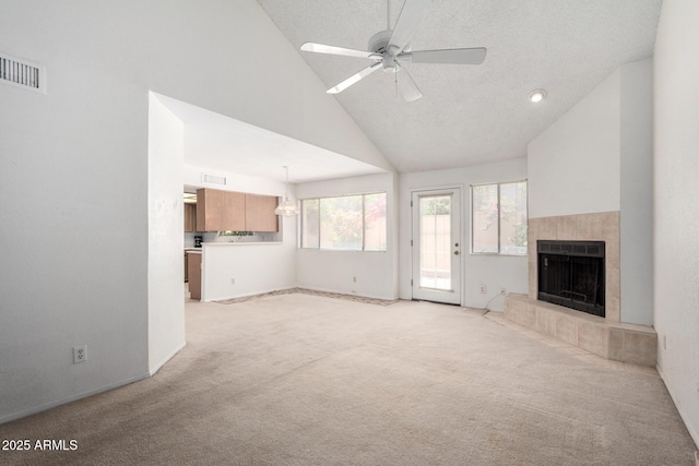 10235 N 31st St Unit 2, Phoenix, AZ 85028 - unfurnished living room with light colored carpet, a tiled fireplace, ceiling fan, high vaulted ceiling, and a textured ceiling