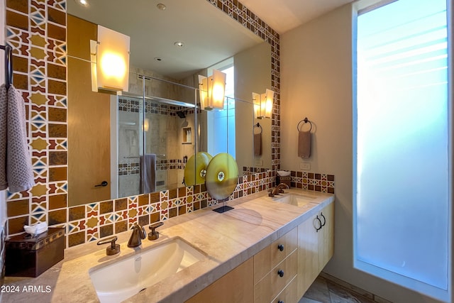 bathroom featuring vanity, tasteful backsplash, and a shower with shower door