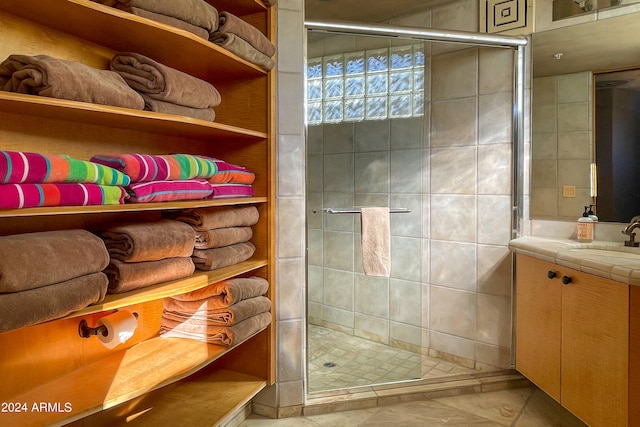 bathroom featuring vanity and a shower with door