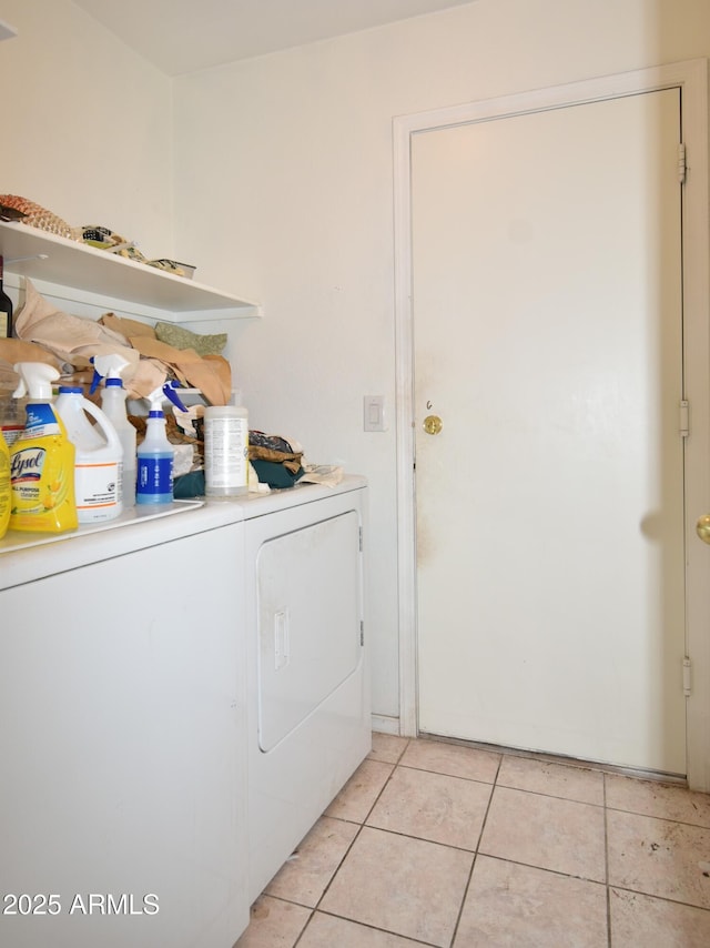 clothes washing area with laundry area, light tile patterned floors, and washer and clothes dryer