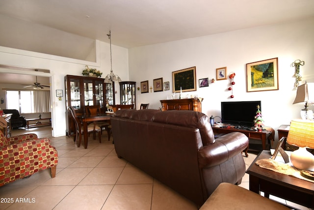 living area featuring lofted ceiling, light tile patterned floors, and ceiling fan