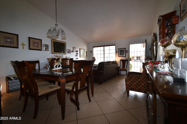 dining area with a chandelier, lofted ceiling, and light tile patterned flooring