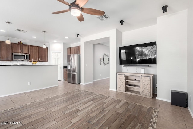 unfurnished living room featuring ceiling fan and hardwood / wood-style floors