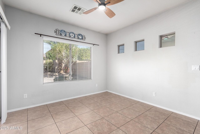 tiled spare room with ceiling fan