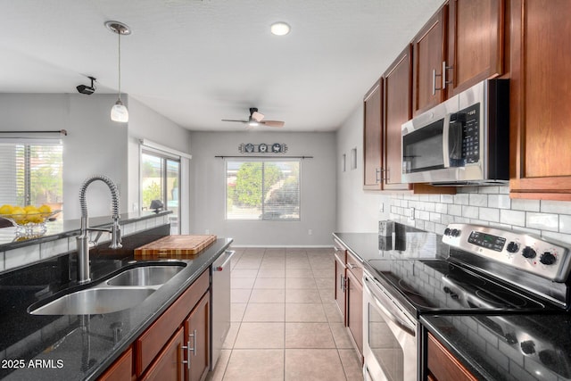 kitchen with stainless steel appliances, tasteful backsplash, light tile patterned flooring, pendant lighting, and sink