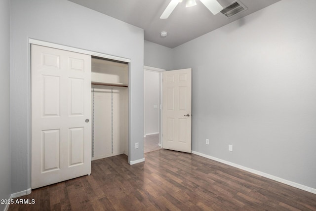 unfurnished bedroom with ceiling fan, dark wood-type flooring, and a closet