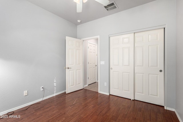 unfurnished bedroom featuring dark wood-type flooring, ceiling fan, and a closet