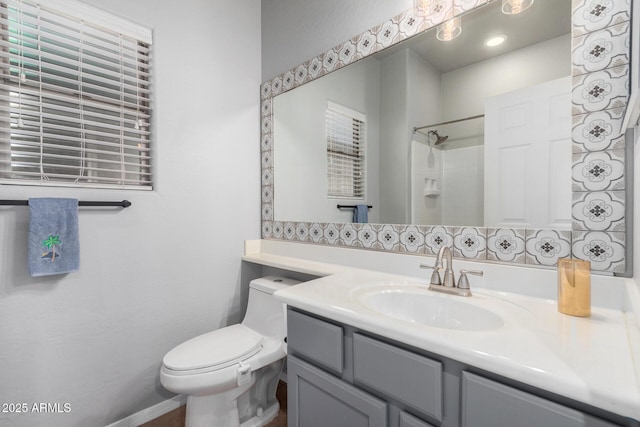 bathroom with walk in shower, vanity, and toilet