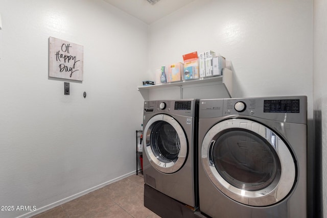 clothes washing area featuring light tile patterned flooring and washing machine and clothes dryer