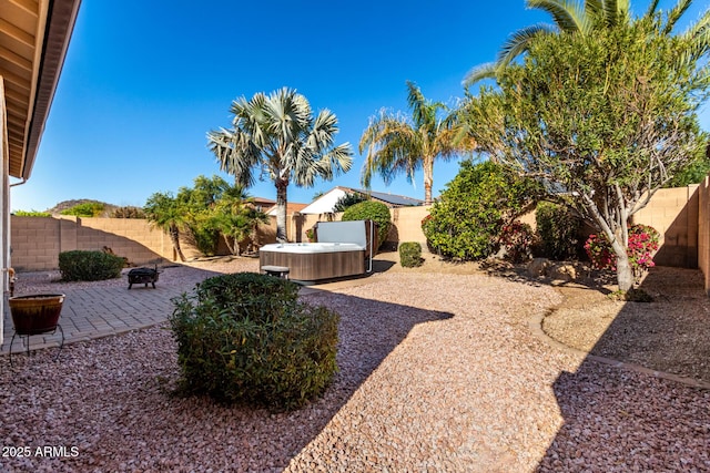 view of yard with a hot tub, a fire pit, and a patio