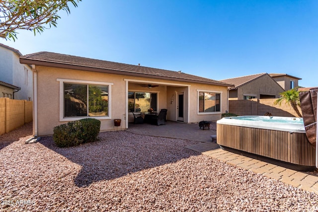 back of house with a hot tub and a patio