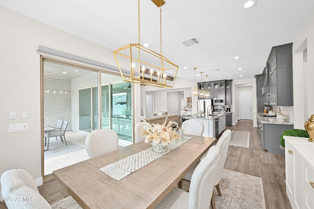 dining space with visible vents, a chandelier, wood finished floors, and recessed lighting