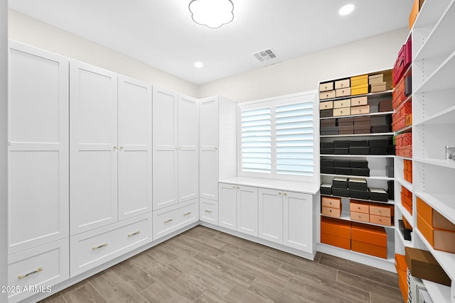 kitchen with open shelves, light wood finished floors, and visible vents