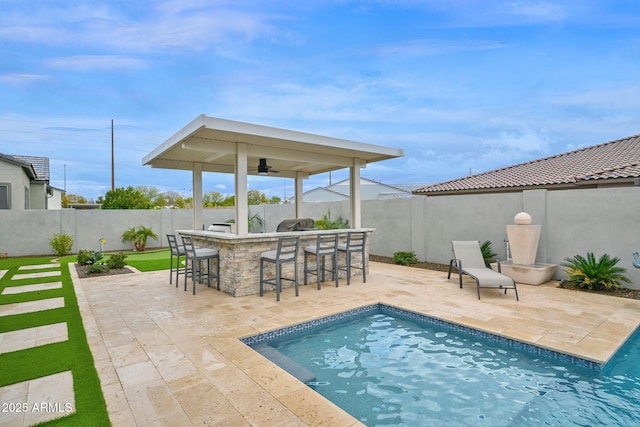 view of pool with outdoor dry bar, ceiling fan, a patio area, and a fenced backyard