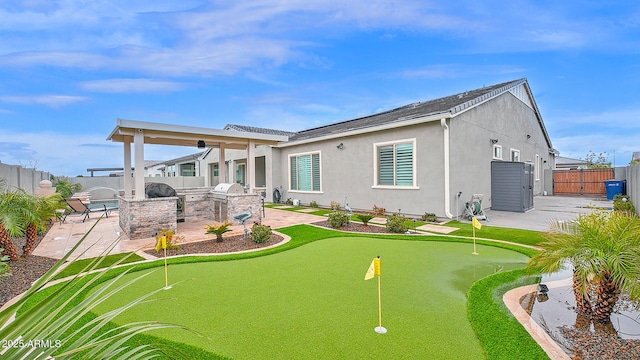 back of house featuring a patio area, a fenced backyard, exterior kitchen, and stucco siding