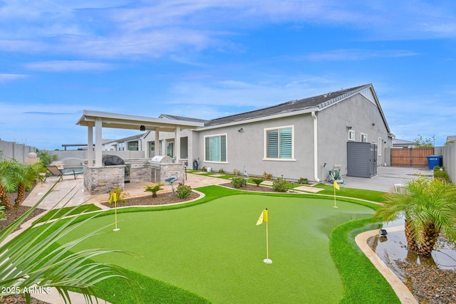 back of house with a patio, an outdoor kitchen, a fenced backyard, and stucco siding