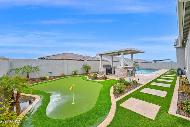 view of yard featuring an outdoor kitchen, a fenced in pool, a patio, a fenced backyard, and outdoor dry bar