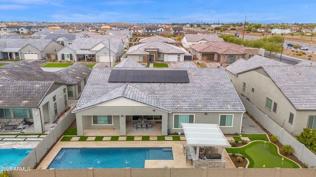 back of property with a fenced in pool, stucco siding, a patio area, a residential view, and a fenced backyard